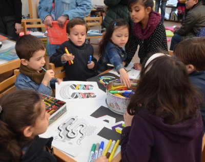 Groupe d'enfants coloriant les lettrines U, M, G, W et B.