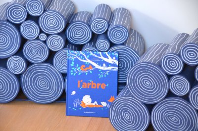 Rondins de bois avec l'album "L'arbre"