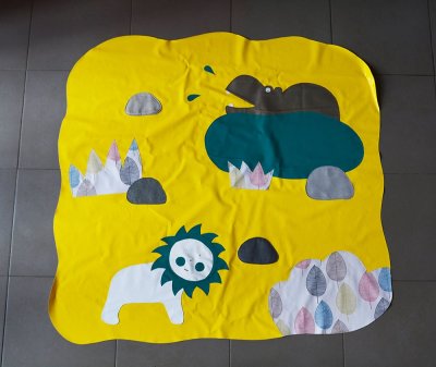 Grand tapis de sol illustratif en toile cirée, à disposer au sol pour installer les bébés - 140x130 cm.