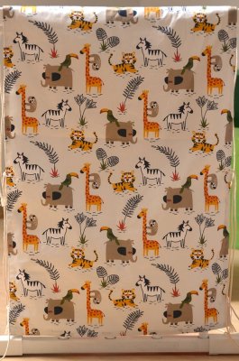 Panneau "Regarde la savane" avec tissu à motifs de girafes, éléphants, zèbres, tigres, toucans et paresseux pour apprendre à observer et nommer.