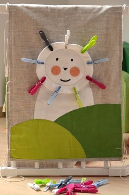 Panneau "La crinière de Petit Lion" et ses 16 pinces à linge en plastique coloré, pour apprendre à manipuler avec finesse.