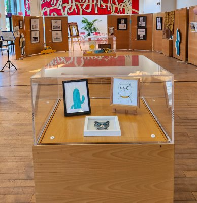 Mise en place sous vitrine dans la salle d'exposition à la Médiathèque de Mâcon juillet 2025