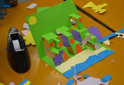 Étape de collage des différents personnages et décors sur la petite structure en volume de chaque enfant.