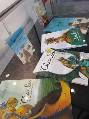 Présentation sous vitrine des albums de la série concernant Charles