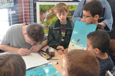 Séance de dédicace de l'illustrateur sous les yeux ébahis des enfants