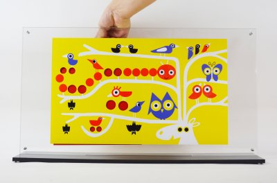 Plexiglass ajouré de l'album "Caché !" avec une page plastifiée pour intéragir avec l'illustration