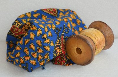 Éléments de scénographie: reste de tissu du pagne confectionné par la maman de Fatinou et la fameuse bobine de fil d'or. Objet réalisé par les étudiants de l'École Emile Cohl de Lyon (69)
