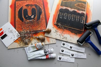 Matériel de gravure: planches de bois gravées, gouges, tubes d'encre à taille douce, rouleaux, palette et copeaux de bois à disposer dans une vitrine.
