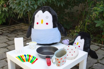 Sayn&egrave;te de la maman de L&eacute;on pr&eacute;parant les cr&egrave;pes. (Tablier bleu nou&eacute;, po&ecirc;le, bo&icirc;te &agrave; sel, tasse, couverts et assiettes).