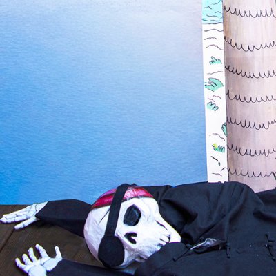 Cr&acirc;ne et mains du squelette attach&eacute;s par des ficelles &agrave; la veste noire en cotton. Grandeur nature.