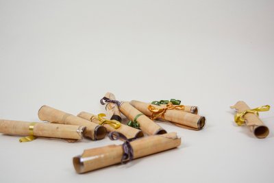 9 parchemins-indices pour la chasse au tr&eacute;sor, plastifi&eacute;s et roul&eacute;s avec un ruban de couleur. Format A5