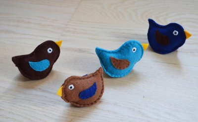 Petits oiseaux en feutrine réalisés par l'illustratrice Coralie Saudo, à disposer dans une vitrine autour du petit nid d'oiseau sous cloche.