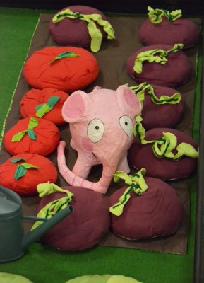 Un petit éléphant rose au milieu des rangées de légumes