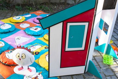 Poupoule sur son tapis et les coussins de diff&eacute;rentes impressions derri&egrave;re le paravent du poulailler.